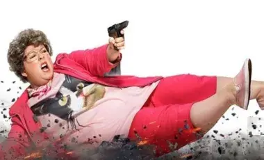 Women laying on the ground holding a gun
