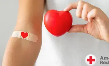 American Red Cross logo with hand holding a heart near arm with a bandaid