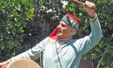 Dance instructor Tom Bozigian in Armenian costume with drum instrument
