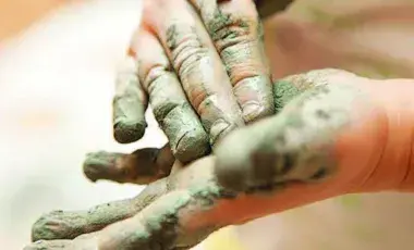 child's hands covered with clay