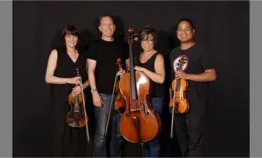 Four members of the Kadima String Quartet pose with their instruments. 