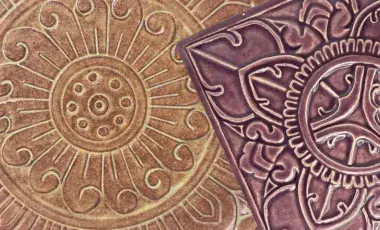 Floral relief on a round, earth-toned ceramic piece and floral relief on a square dark brown ceramic piece.
