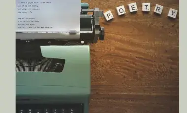 a type writer and block letters that spell poetry