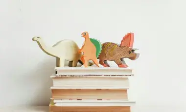Toy dinosaurs on a stack of books