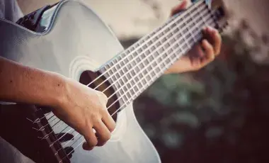 Hands playing a guitar.
