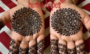 Two upturned hands are shown. Both have elaborate henna tattoos on the palms and fingers.