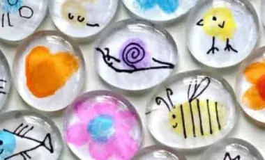 An assortment of thumb print magnets, featuring colorful animals, insects, and flowers. 
