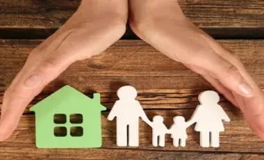 Two Hands covering a house a paper cut out humans
