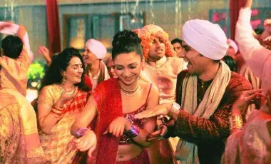 women and men in lavish Indian clothes dancing