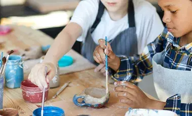 children using different tools to decorate their clay creations