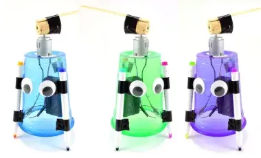 Three art bots, one blue, one green, and one purple stand as finished examples of the activity.