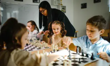 girls and boy playing chess