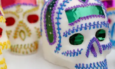 Several sugar skulls decorated with colorful icing and foil.
