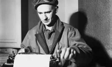 black and white image of Ernie Pyle seated and using a typewriter