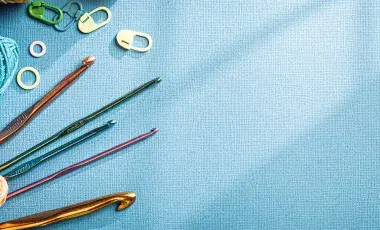An assortment of yarn, crochet hooks, and stitch markers