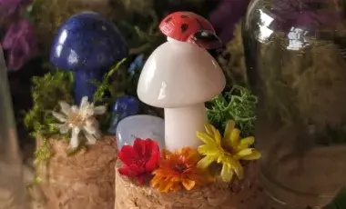 white crystal mushroom with a ladybug on top is surrounded by colorful flowers
