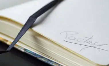 Close up of a page in a journal with the word poetry written on it.