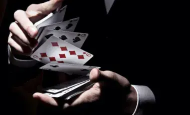 stock image of a pair of hands shuffling a deck of cards