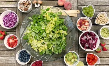 A picture of salad greens surrounded be ingredients. Image by Silvia from Pixabay