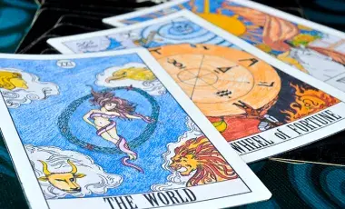 Three tarot cards lay face up on a table.