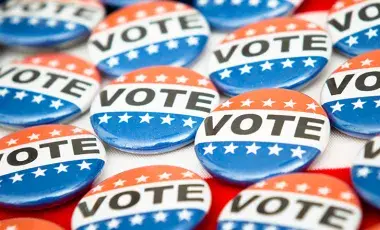 Several red, white, and blue buttons with the word vote written in black letters.