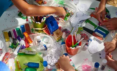 children at a table using arts and crafts supplies 