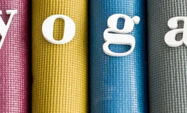 4 colorful yoga mats rolled up next to each other