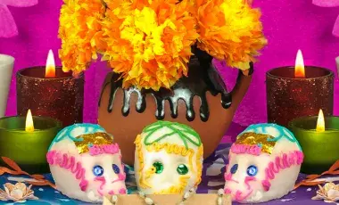 Sugar skulls and lit candles on a Day of the Dead altar