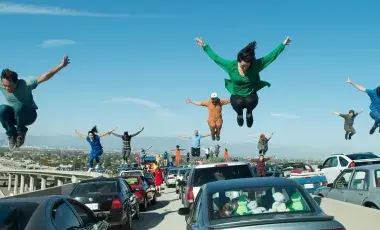 Dancers suspended in jumps above the cars on the 105/110 Interchange 