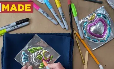 a set of hands coloring in a piece of tin work