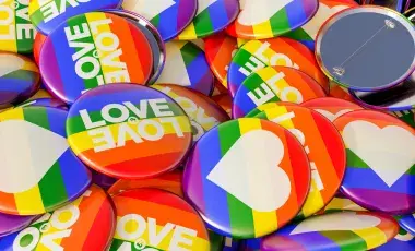 Buttons with hearts and pride slogans printed on rainbow flags