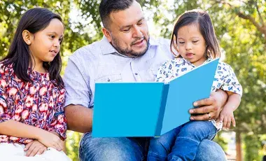 a father reads with 2 kids