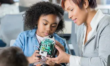 child and adult working on robotics 