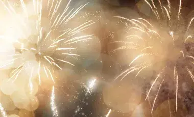 Fireworks exploding in shades of white, yellow, and gold.