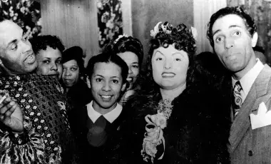 men and women in evening clothes standing together and smiling at the camera