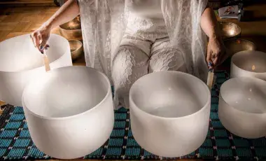 person playing white sound healing bowls