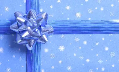 Blue wrapping paper with snowflake design and blue ribbon bow