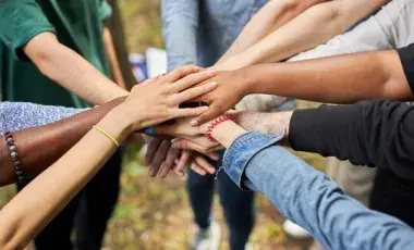 People placing their hands together in a circle