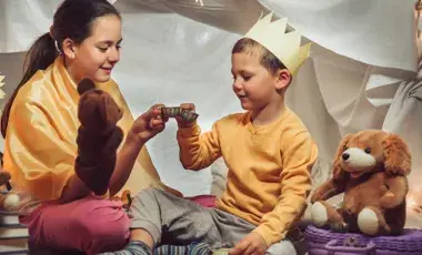 Two children enjoy a whimsical tea party inside a fort