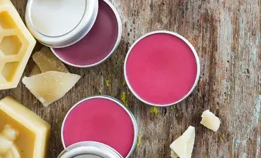 Tins of pink lip balm and beeswax tablets