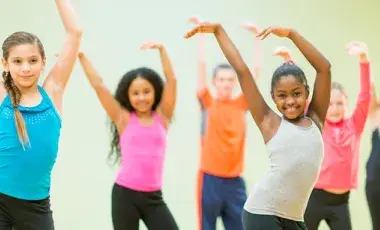 Children are waiving their arms while exercising.