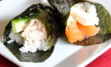 cones of seaweed filled with sushi and green vegetables and white rice