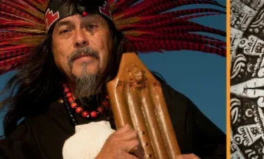 Martin Espino in Indigenous clothing and headdress with a flute