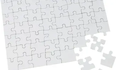 Unassembled white jigsaw puzzle pieces