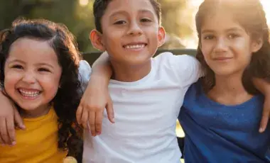 young children girls and boys smiling with arms around each other