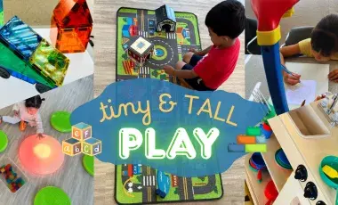 Children playing with magnatiles, light tables, a toy car town, play kitchen, and tracer