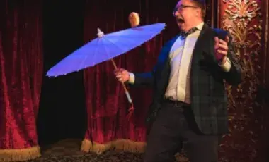 Michael Rayner juggles a cheeseburger on an umbrella