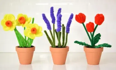 Three flower pots with different flowers made with pipe cleaners. 