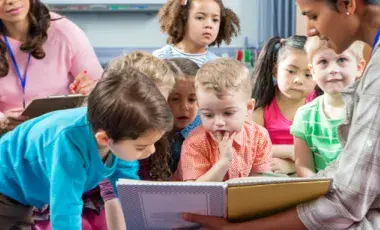 children listening to a story being read by a librarian
