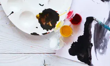 yellow paint, red paint, and white paint on a canvas, palette, and paint brush